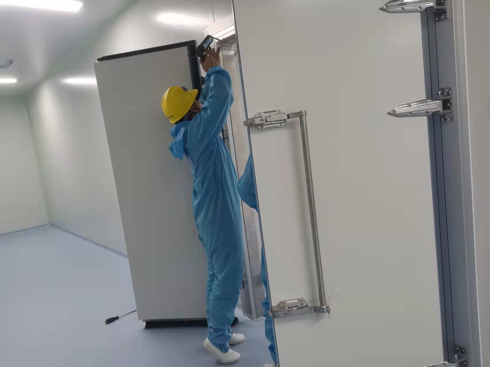 圖為浩爽工人在潔凈冷庫為庫門打膠