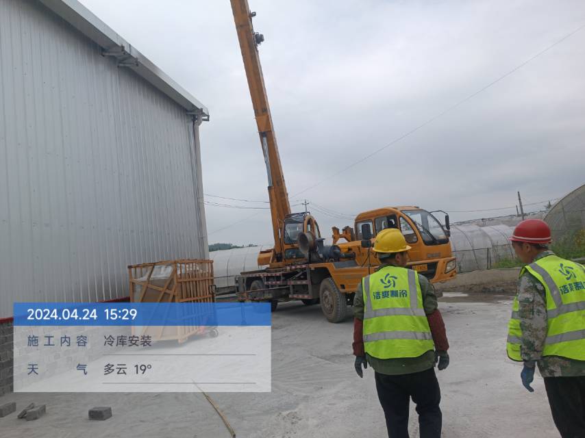 圖為浩爽工人正在吊裝制冷機(jī)組